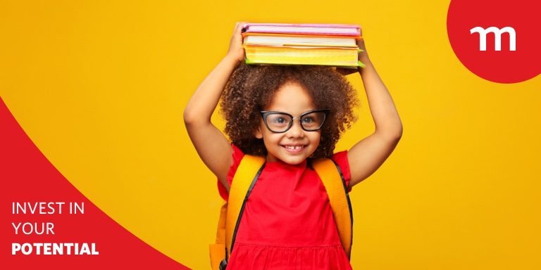 Smiling little child wearing glasses and holding books above her head.
