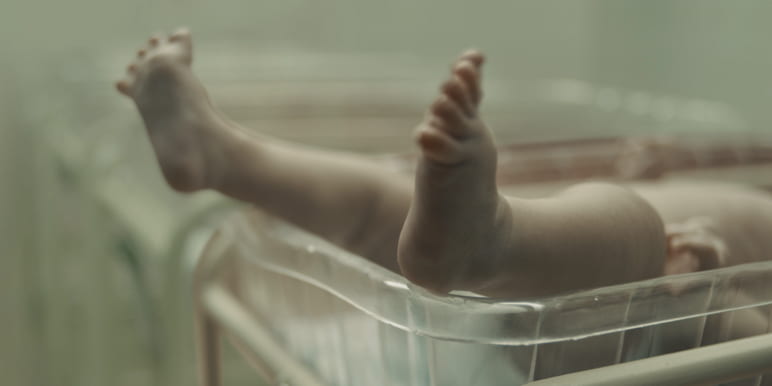 A newborn baby in a hospital nursery.