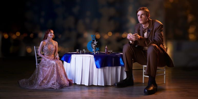 Alice and Matt seated at a table decorated with a white tablecloth and blue decorations.