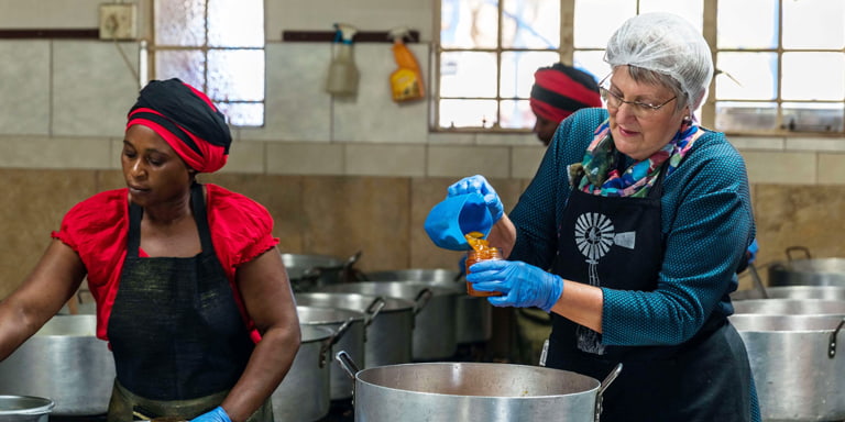 Since 1990 Ina Lessing has been preparing her delicious jams and preserves and is seen here working in her kitchen with one of her employees pouring freshly made jam, taken from a pot on the stove, into a glass jar.