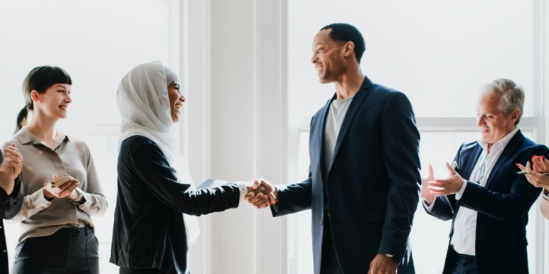 A man and a Muslim woman shaking hands