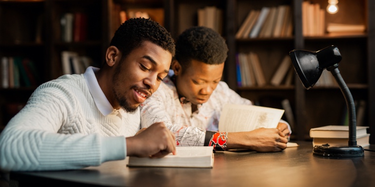 Two young Black men studying at a table