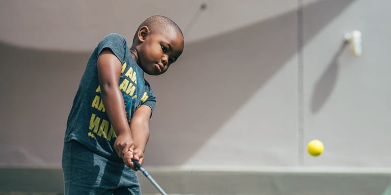 Ngobani Dlamini with a look of concentration as he hits the golf ball.