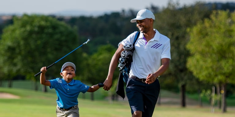 Ngobani raises his golf club in elation while walking with his dad, Mpumi, hand-in-hand on the golfing greens.