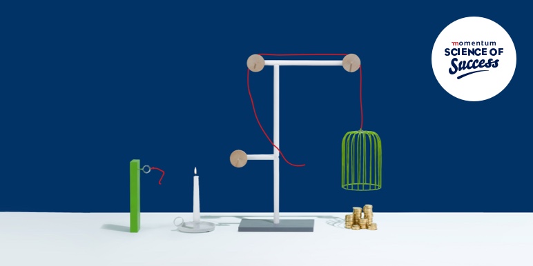 A science experiment to show a sequence of events using a candle, string, cage and money coins.