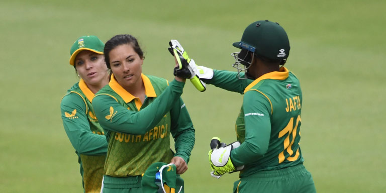 Teammates from the Momentum Protea’s cricket team high-five each other. 