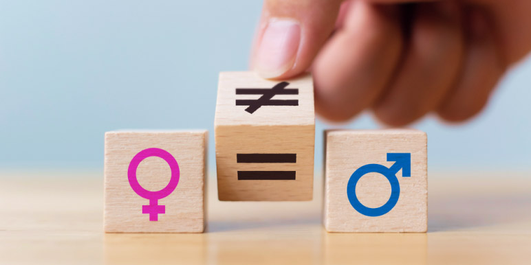 Three wooden blocks: the first has a female symbol, the second has both the equal and not equal signs, and the third has the male symbol.