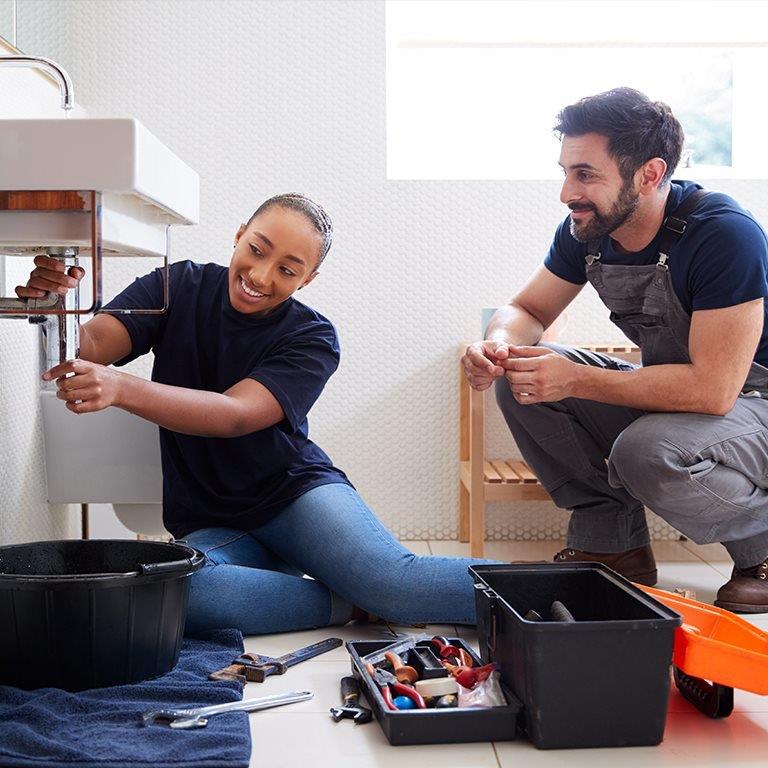 A couple fixing a bathroom sink