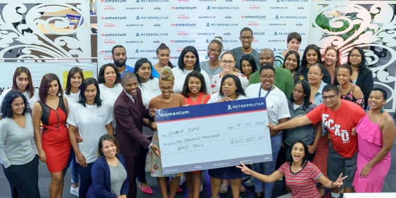 A group of people happily receiving a big check.