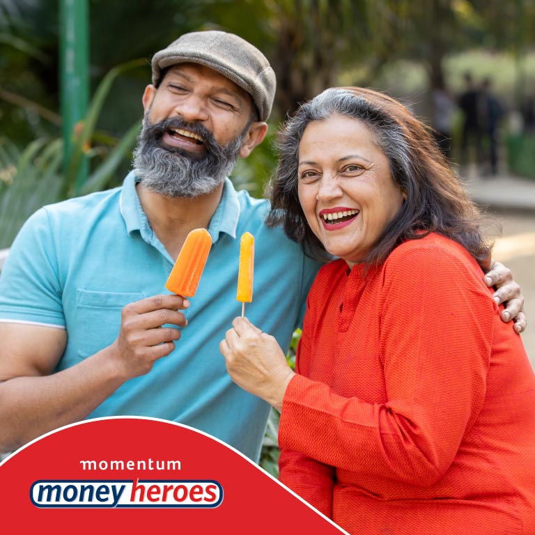 An elderly couple eating ice lollies while walking in a park. They got in touch with their financial adviser and got the advice they needed to make sure they saved for their retirement.