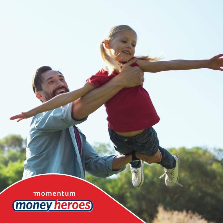 Carefree dad holds his young daughter who pretends to be a superhero plane. 