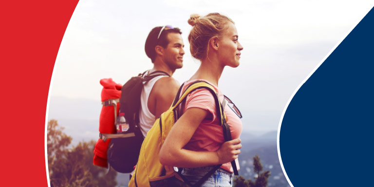 A healthy and fit couple on a hospital plan out on a hike taking a break and looking at the view.