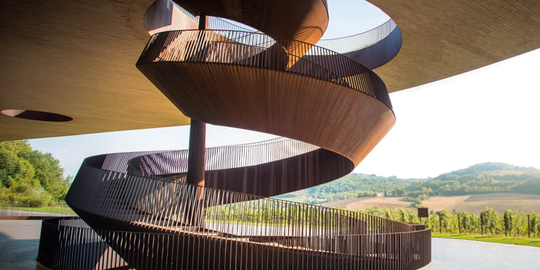 A spiral staircase displaying modern, artistic architecture which is in the shape of a cork screw.