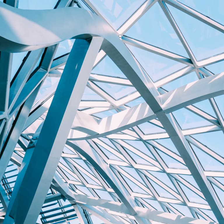 A multi-triangle shaped connected silver structure with a blue sky background.