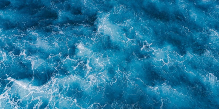 An aerial view of rough, deep blue sea water