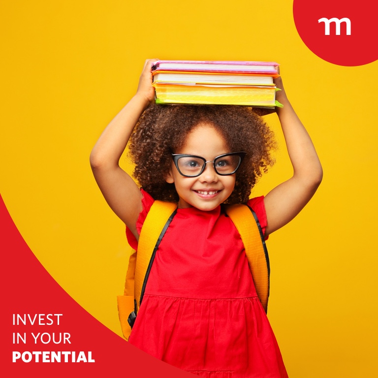 Smiling little child wearing glasses and holding books above her head.