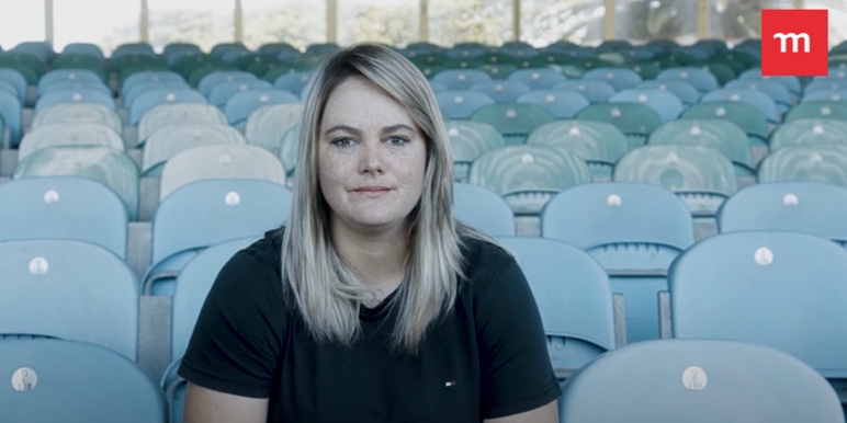 A white woman sitting down facing forward.