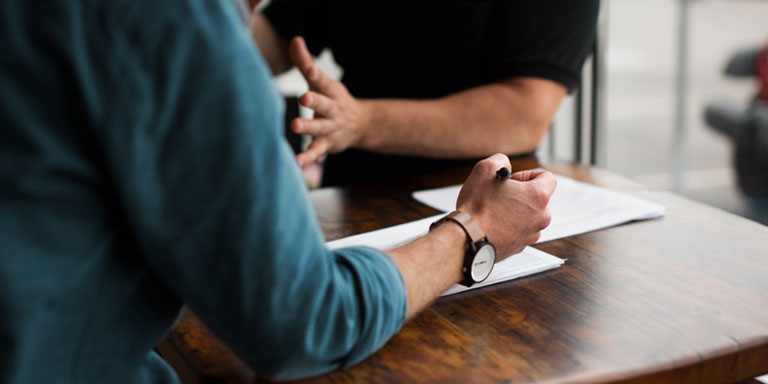 A financial adviser talking to a client about having critical illness, disability and loss of income cover.